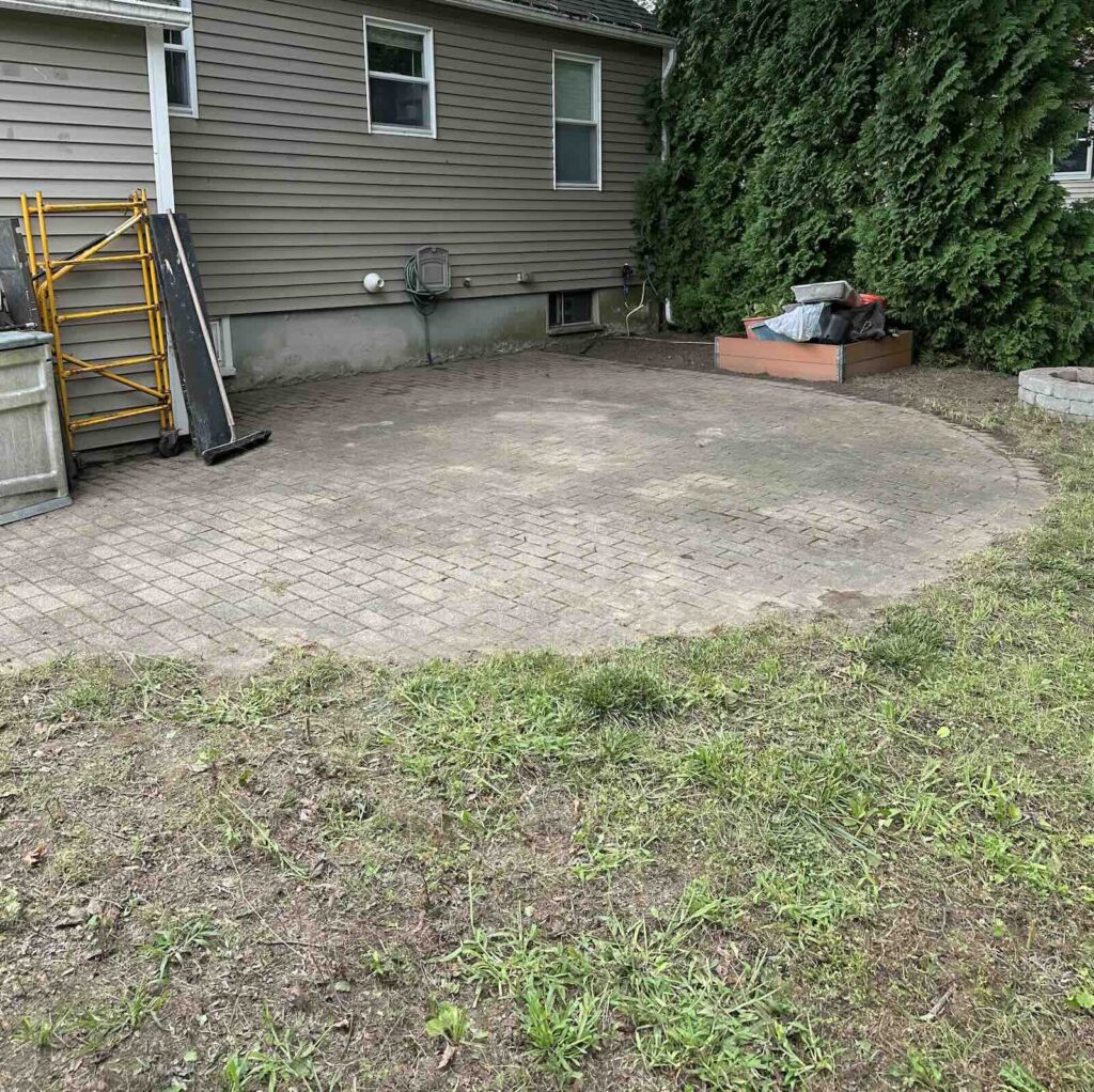 Clean patio area after landscape cleanup with leaves, weeds, and branches removed in Dover NH