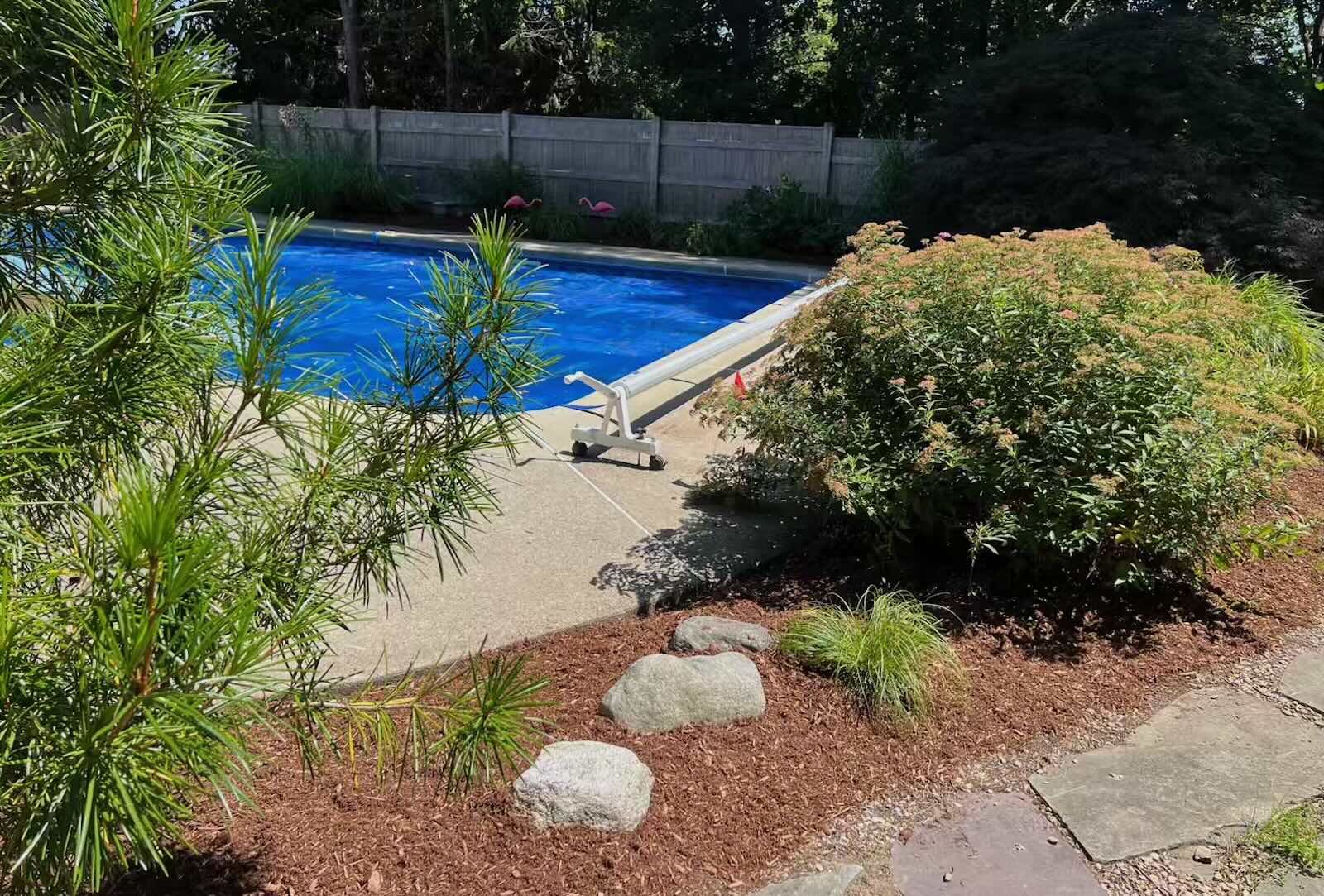 Fresh organic mulch installed in landscape beds around pool in Stratham NH