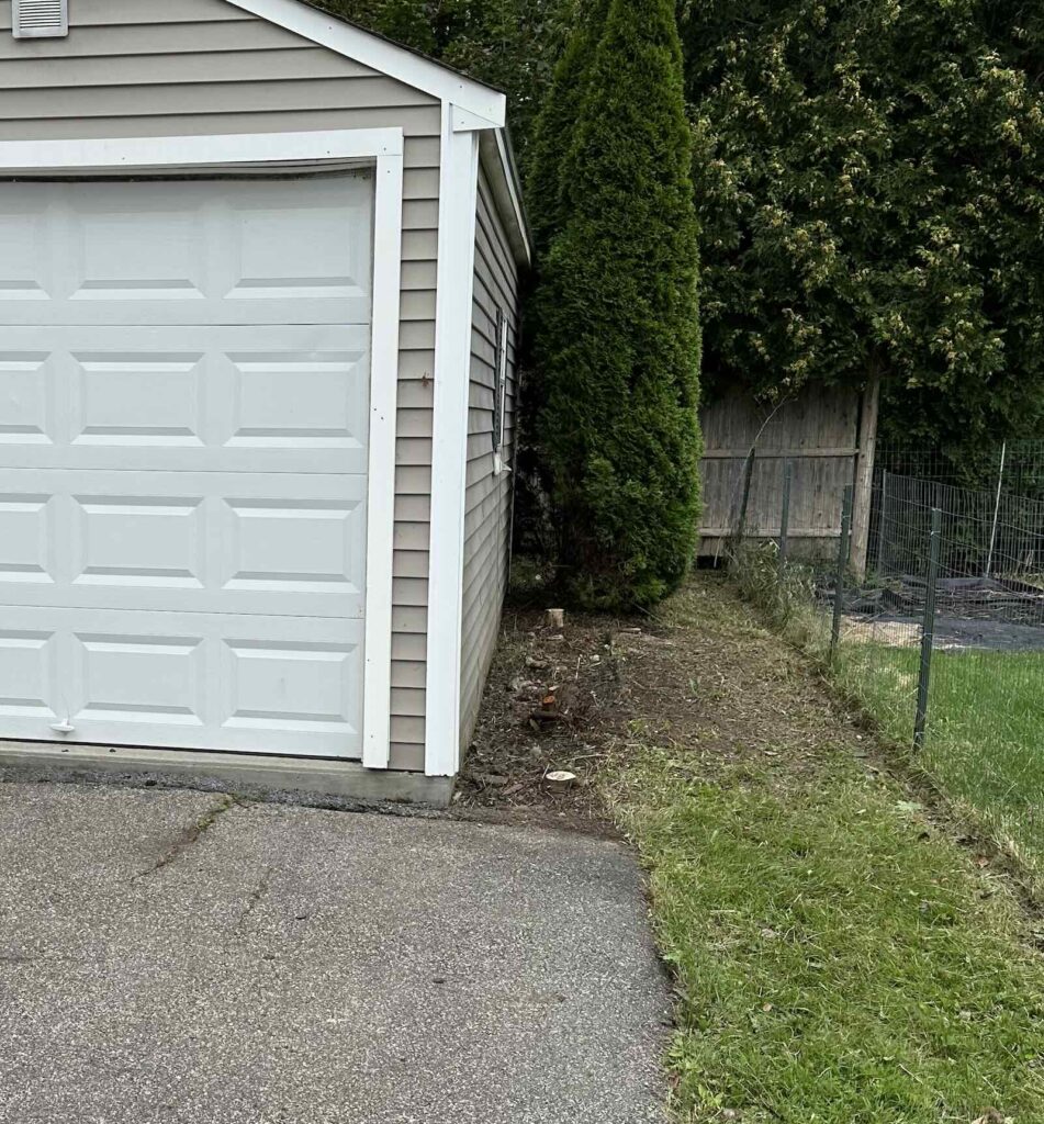 Clean cleared landscape area around garage after overgrowth removal in Kittery ME