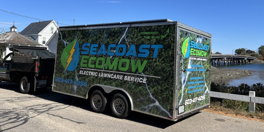 Seacoast EcoMow truck and trailer with solar panels overlooking the water during landscaping service in Greenland NH