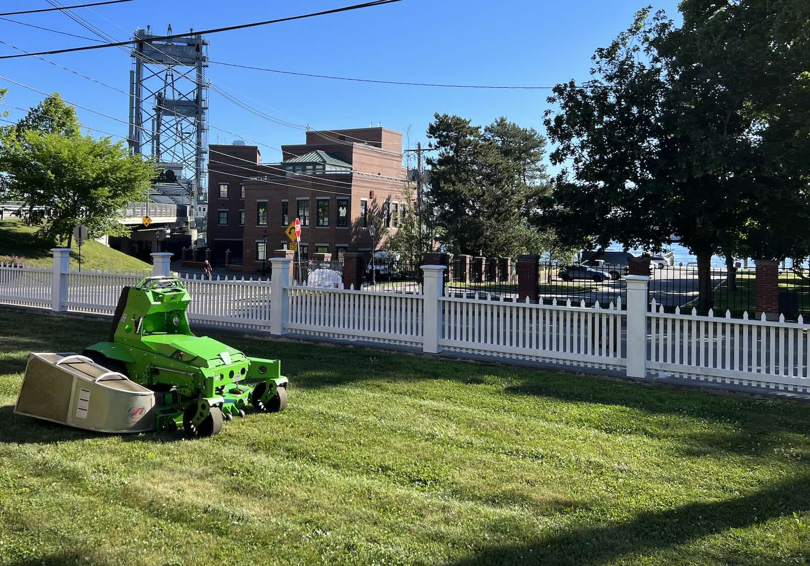 Professional Landscaper – Portsmouth NH Mean Green mower striping lawn overlooking Prescott Park, the Piscataqua River, and the Sarah Long Bridge in Portsmouth NH