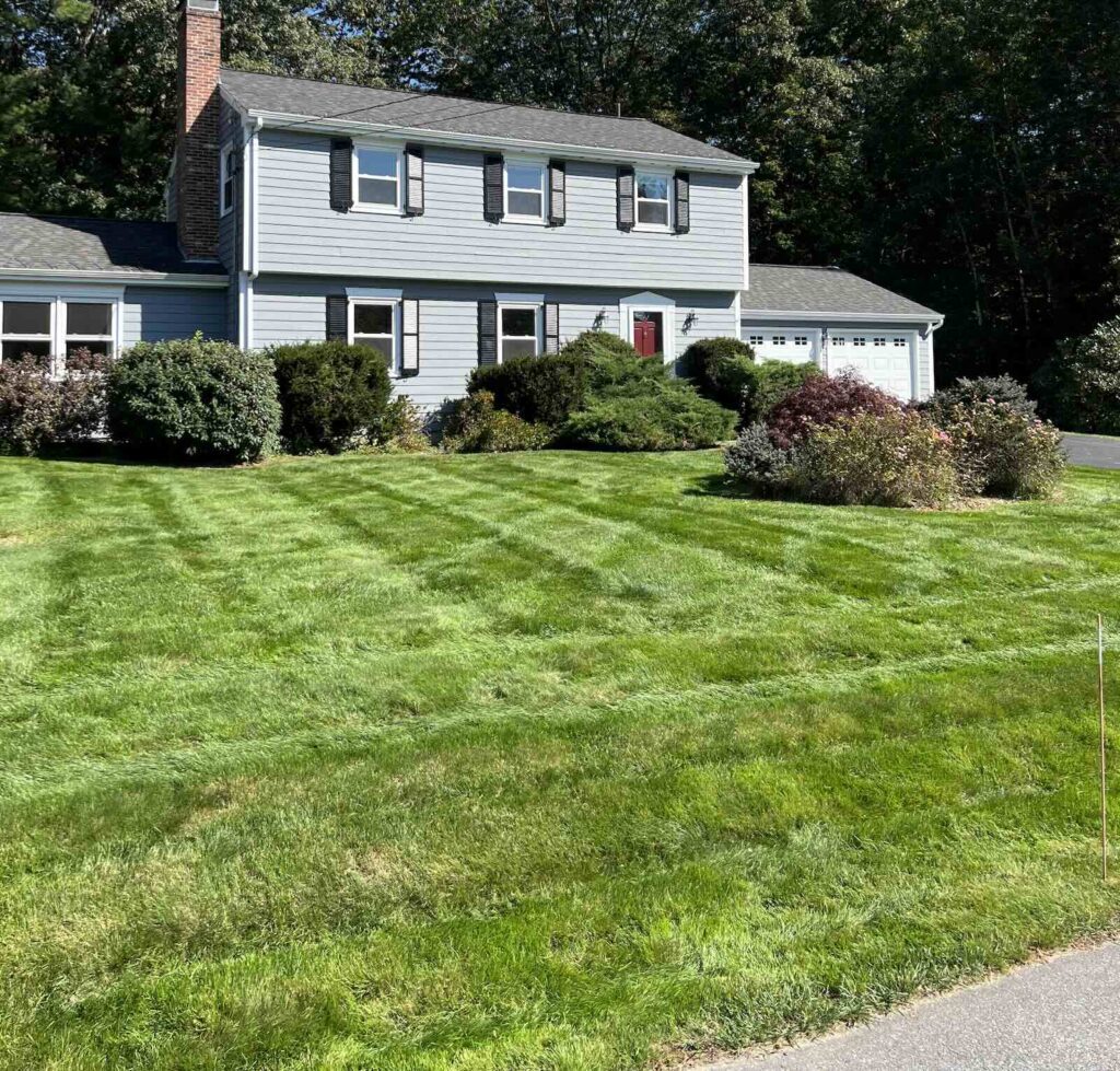Freshly striped front yard lawn after landscaping and mowing service in Durham NH